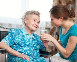 Giving water to elderly female